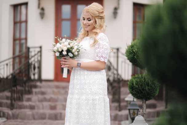 Female hold bouquet of white roses in hands. Mini wedding. Blond hair bride with bouquet of flowers - Фото, зображення