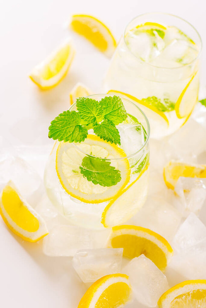 Lemonade drink in a glass: water, ice, lemon slice and mint - Photo, Image