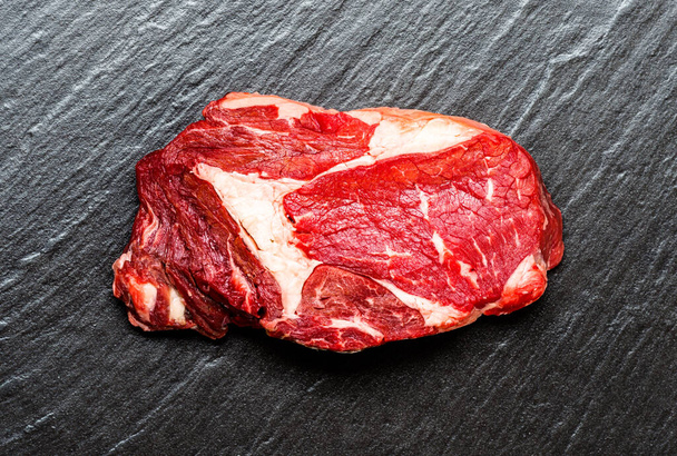 Vue de dessus sur la surface en pierre avec steak cru gros plan - Photo, image