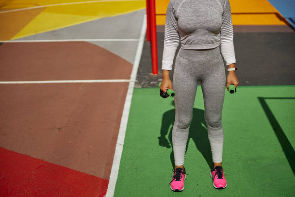 Bella sana allegra donna sorridente allenamento in una piazza di allenamento urbano colore della città - Foto, immagini