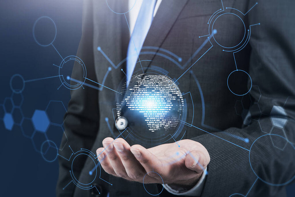 Unrecognizable young businessman holding Earth hologram over blurry blue background with double exposure of immersive network interface. Toned image - Photo, image