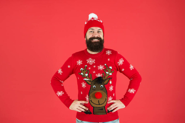Christmas carols. lets go shopping. time for choosing a gift. should i wear warm clothes. bearded man in knitted accessory. its christmas time. happy new year. smiling hipster red background - Photo, image