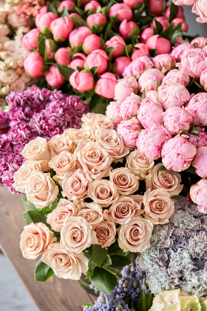 Çiçekçide stantta ya da ahşap masada çok farklı renkler var. Gösteriş. Çiçeklerin karışımı. Katalog veya çevrimiçi mağaza için güzel çiçekler. - Fotoğraf, Görsel