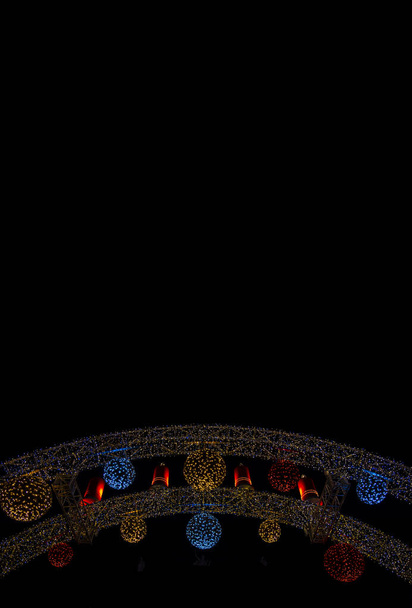 Χριστουγεννιάτικη νύχτα δρόμου διακόσμηση γιρλάντα λαμπτήρες φωτισμού σε μαύρο φόντο υπαίθριο χώρο κάθετη εικόνα ταπετσαρία patter μορφή με κενό χώρο αντίγραφο για το κείμενό σας εδώ - Φωτογραφία, εικόνα