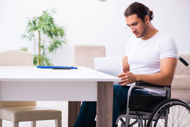 Młody niepełnosprawny mężczyzna pracujący w domu - Zdjęcie, obraz