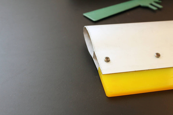Roue métallique sérigraphie, applicateur métallique et spatule verte avec fond noir - Photo, image