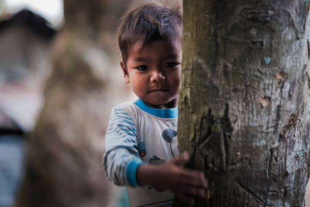 Muadzam Shah, Malesia - 7 febbraio 2020: Un bambino indigeno della Malesia o Orang Asli con la faccia felice che sale sull'albero. - Foto, immagini
