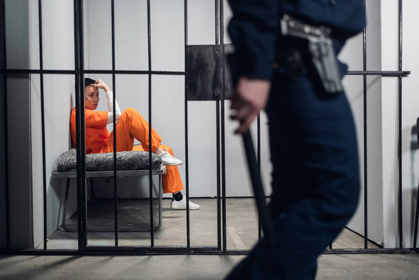 Ein gefährlicher Verbrecher chinesischer Herkunft wird von einem Polizisten in einer Einzelzelle bewacht. Ein Gefängnis mit höherem Schutzniveau. - Foto, Bild