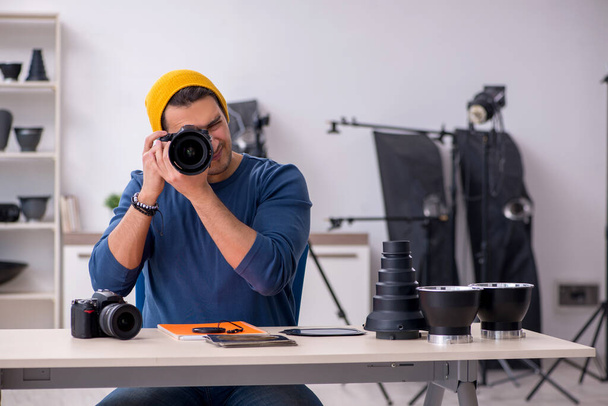 Nuori miesvalokuvaaja työskentelee studiossa - Valokuva, kuva