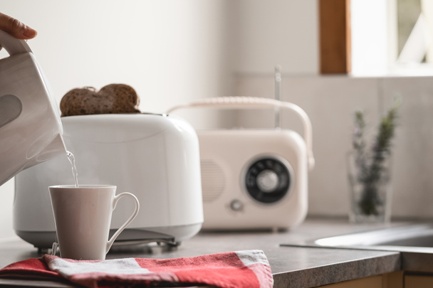 Hora do pequeno-almoço com chaleira eléctrica, torradeira e um antigo rádio vintage. Fundo branco - Foto, Imagem