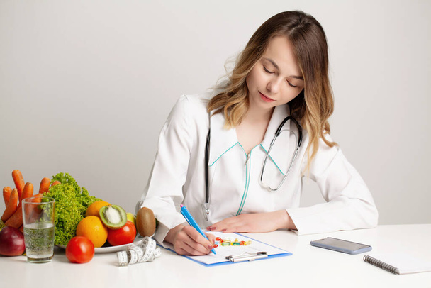 Junge Ernährungsberaterin Arzt schreibt Diätplan, gesunde Ernährung - Foto, Bild