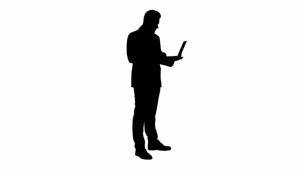 Silhouette Businessman standing and using laptop. - Фото, изображение