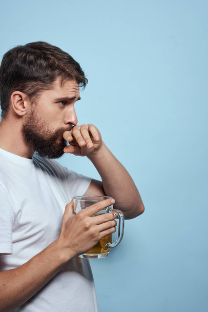 Bearded man beer mug alcohol white t-shirt side view blue background - Photo, image