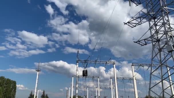 Poste eléctrico con alambres de alto voltaje cerca contra un cielo azul - Metraje, vídeo