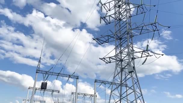 Poste eléctrico con alambres de alto voltaje cerca contra un cielo azul - Metraje, vídeo