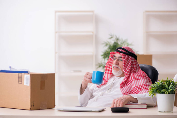 Старый арабский бизнесмен в концепции переселения офиса - Фото, изображение