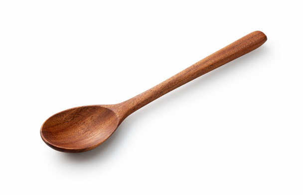 Foto en ángulo de una cuchara de madera colocada sobre un fondo blanco - Foto, Imagen