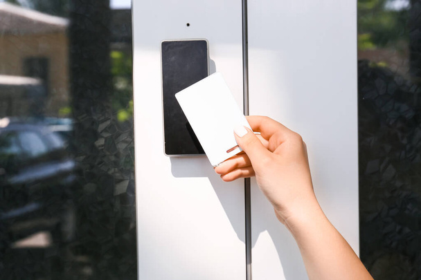 Donna che usa la carta per aprire la porta all'aperto - Foto, immagini