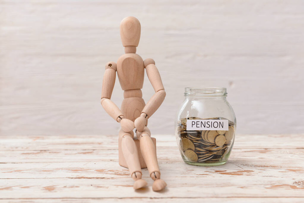 Mannequin and jar with savings on table. Concept of pension - Photo, Image