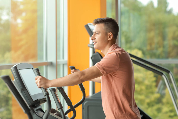 Young man training on exercising bike in gym - Photo, Image