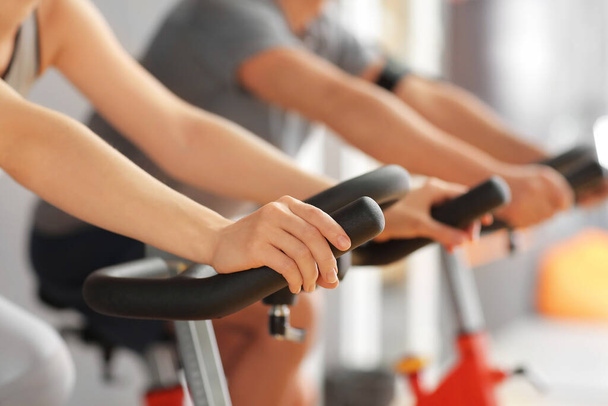 Young woman training on exercising bike in gym, closeup - Fotoğraf, Görsel
