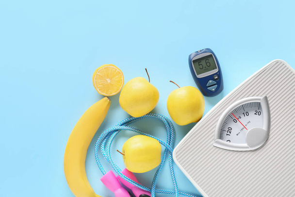 Frutas, escamas, cuerda de salto y glucosímetro sobre fondo de color. Concepto de diabetes - Foto, imagen