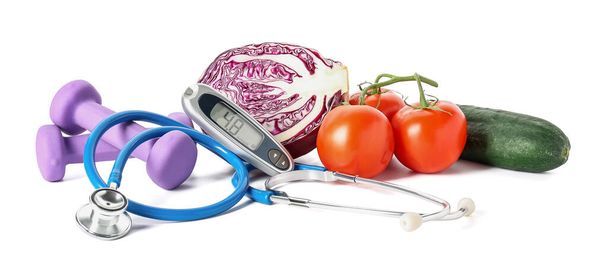 Vegetables, dumbbells, stethoscope and glucometer on white background. Diabetes concept - Photo, Image