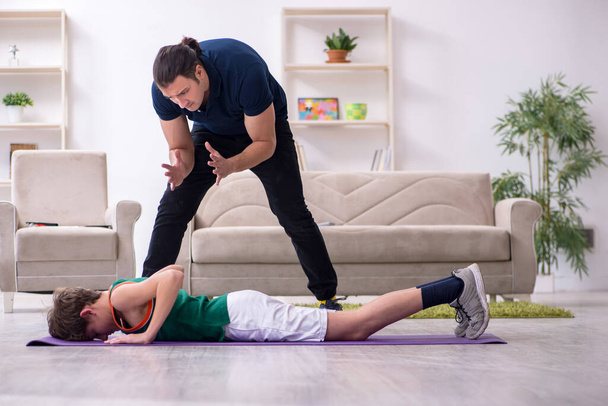 Father and son doing sport exercises indoors - Foto, afbeelding