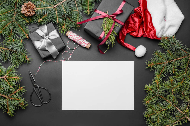 Beautiful Christmas decorations with gifts and empty card on dark background - Photo, Image