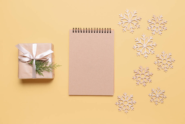 Beautiful Christmas gift with empty notebook on color background - Φωτογραφία, εικόνα