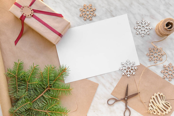 Beautiful Christmas decorations with empty card, gift and envelope on white background - Photo, Image
