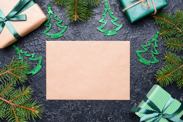 Schöne Weihnachtsgeschenke und leere Karte auf dunklem Hintergrund - Foto, Bild