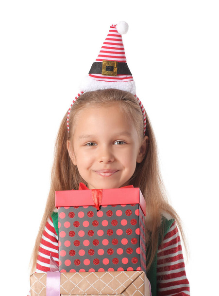 Schattig klein meisje verkleed als elf en met kerstcadeaus op witte achtergrond - Foto, afbeelding