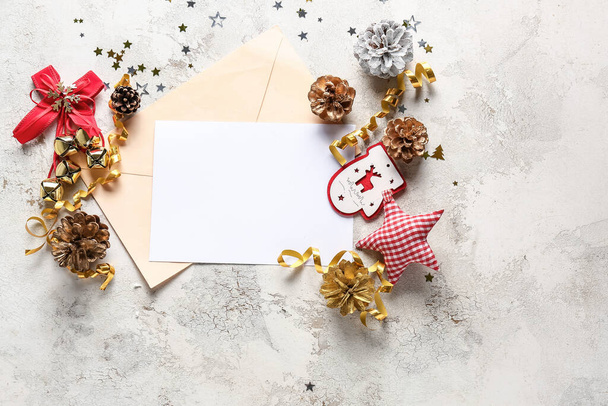 Gyönyörű karácsonyi dekorációk üres kártya és boríték világos háttér - Fotó, kép