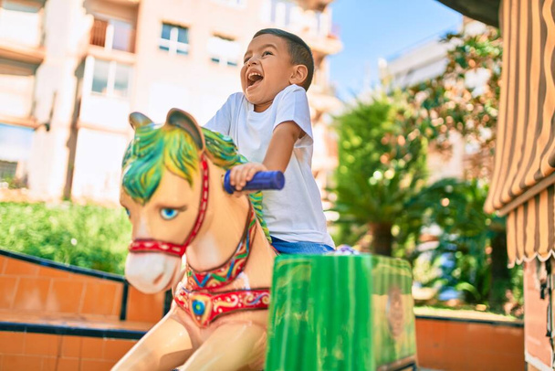 Sevimli İspanyol çocuk gülümsüyor. Parkta oynayarak mutlu oluyor.. - Fotoğraf, Görsel