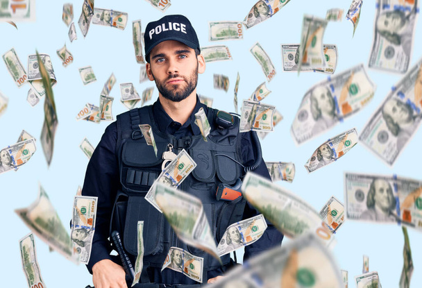 Homem bonito jovem com barba vestindo uniforme policial relaxado com expressão séria no rosto. simples e natural olhando para a câmera. - Foto, Imagem