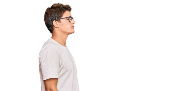 Handsome caucasian man wearing casual clothes and glasses looking to side, relax profile pose with natural face and confident smile.  - Φωτογραφία, εικόνα