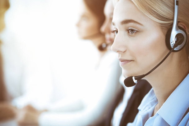 Call center and business people concept. Beautiful business woman with headphones consulting clients - Fotoğraf, Görsel