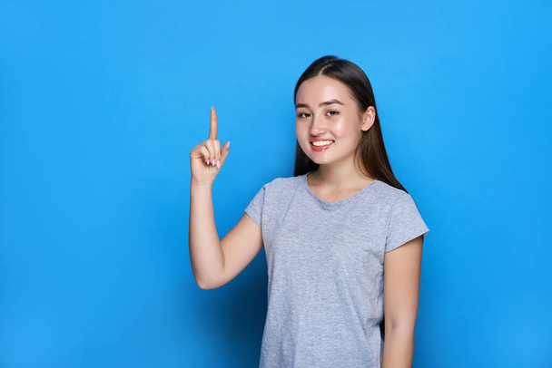 Young beautiful asian smiling and showing thumbs up on blue background. - Fotoğraf, Görsel