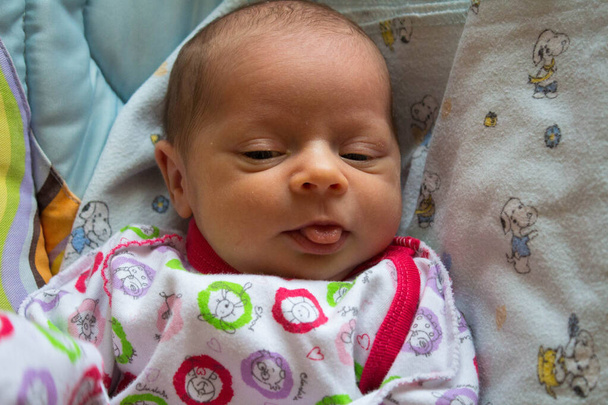 egy újszülött megmutatja a nyelvet a bölcsőben - Fotó, kép