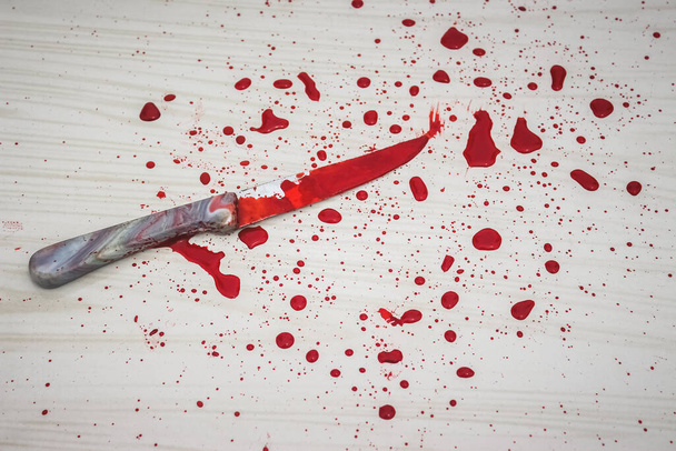 Blutiges Messer auf dem Boden. Am Tatort wurde ein Messer gefunden. Ein Gerichtsmediziner entnimmt Blutproben aus dem Messer. Blutiges Messer liegt auf Keramikfliesen im Hintergrund. Konzept einer häuslichen Tötung. - Foto, Bild