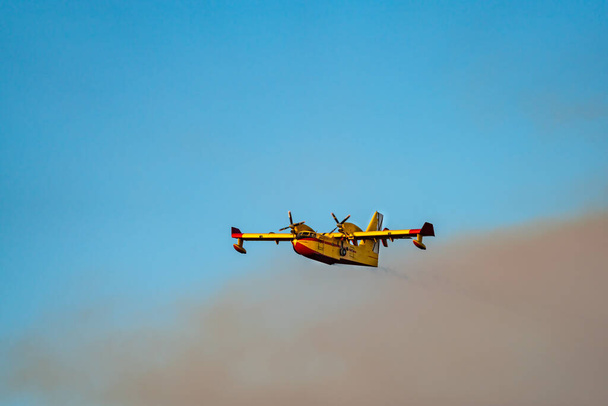 Hidroavión volando del humo del fuego - Foto, imagen