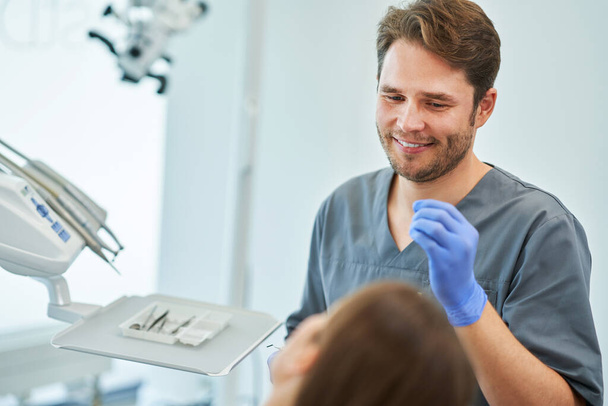 Чоловік-стоматолог і жінка в кабінеті стоматолога
 - Фото, зображення