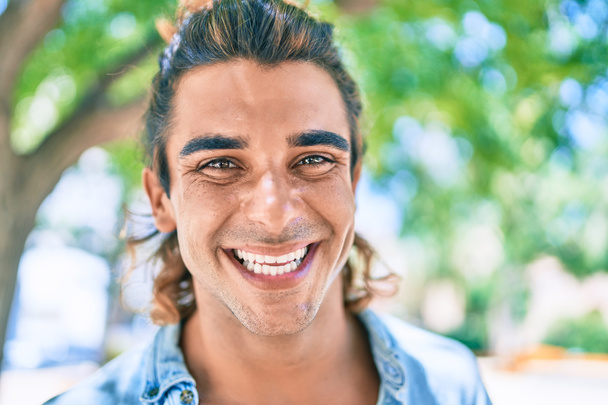 Joven hombre hispano guapo sonriendo feliz caminando en la calle de la ciudad - Foto, Imagen