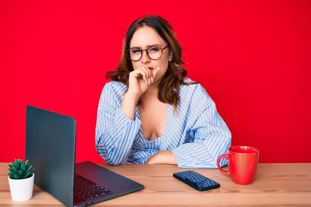 Young beautiful caucasian woman working at the office with laptop feeling unwell and coughing as symptom for cold or bronchitis. health care concept.  - 写真・画像