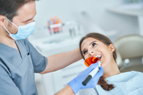 Άντρας οδοντίατρος και γυναίκα στο οδοντιατρείο - Φωτογραφία, εικόνα