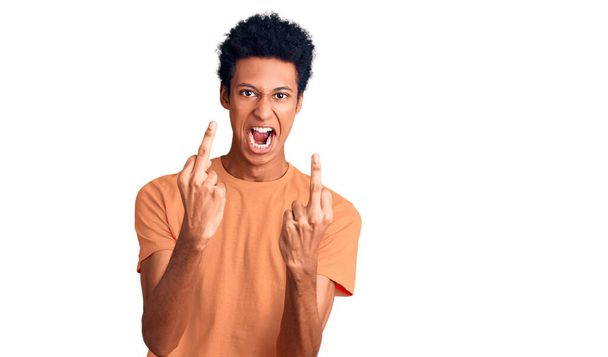 Joven hombre afroamericano vistiendo ropa casual mostrando el dedo medio haciéndote follar mala expresión, provocación y actitud grosera. gritando excitado
  - Foto, imagen
