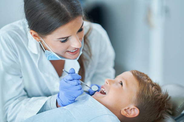 Mały chłopiec i kobieta dentysta w gabinecie dentystycznym - Zdjęcie, obraz