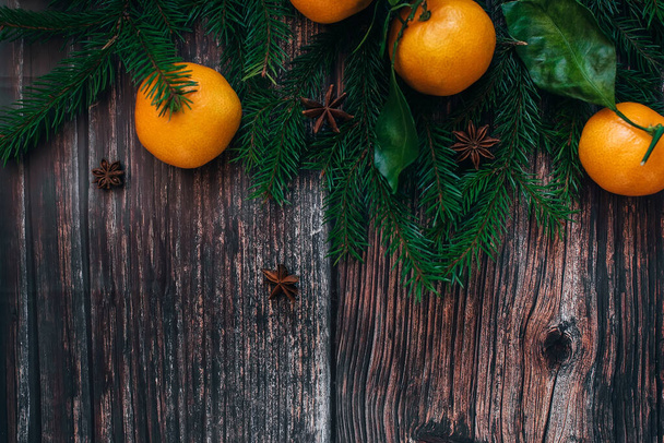 fir branches, tangerines and aniseed stars on a wooden - Фото, зображення