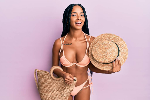 Beautiful hispanic woman wearing bikini and summer hat smiling and laughing hard out loud because funny crazy joke.  - Foto, immagini